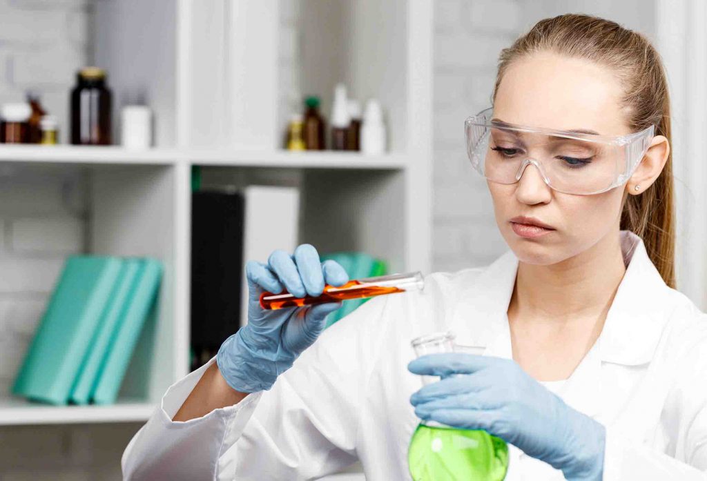 forscherin mit handschuhen und reagenzglasern
