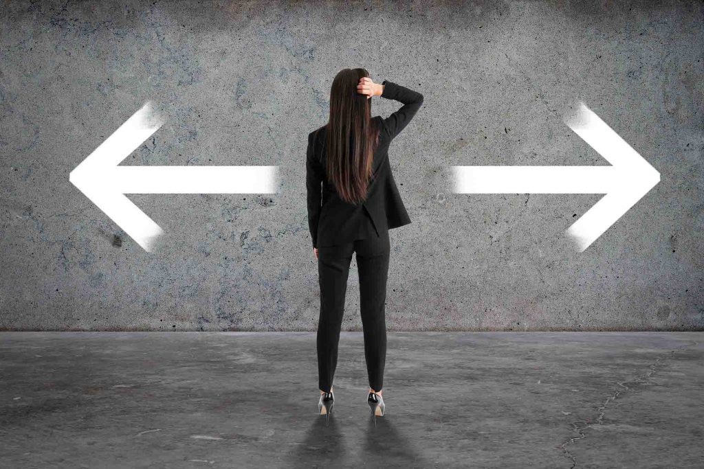 back view of businesswoman with two arrows in concrete interior. different direction and choice concept.